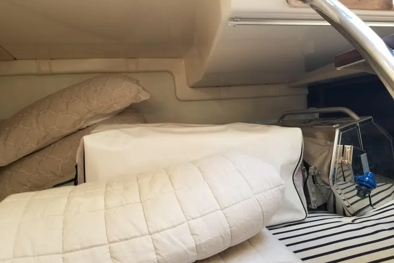 Slide: The Image of Cozy cabin interior of 2018 Regal 28 Express with pillows and striped bedding. - 13