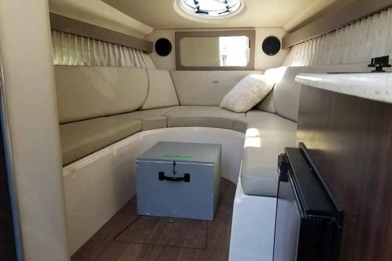 Slide: The Image of 2018 Regal 28 Express cabin interior with beige seating and compact table. - 14