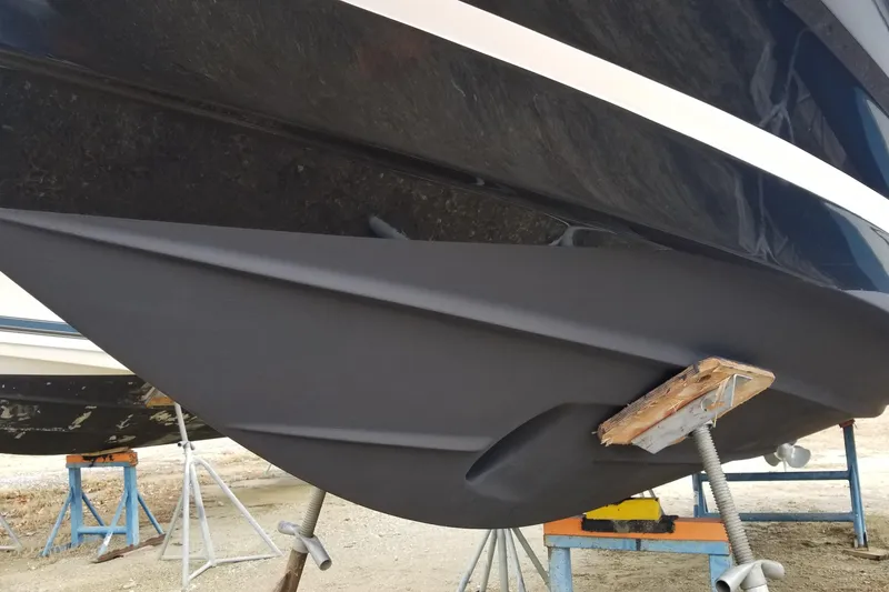 Slide: The Image of 2018 Regal 28 Express boat hull on stands, showcasing sleek design and craftsmanship. - 2