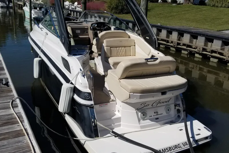 Slide: The Image of 2018 Regal 28 Express boat docked, featuring beige seating and sleek design. - 4