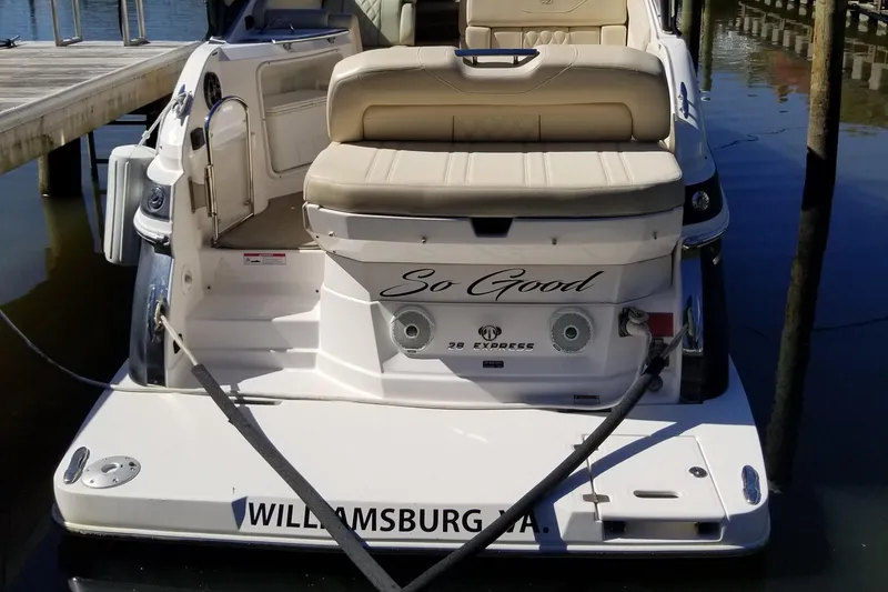 Slide: The Image of 2018 Regal 28 Express boat docked, featuring beige seating and "So Good" on the stern. - 5