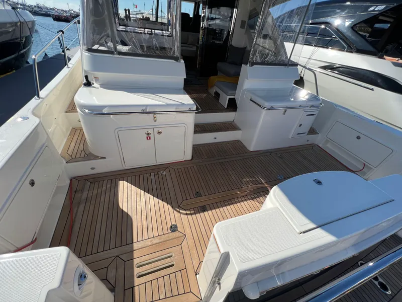 Slide: The Image of 2022 Riviera 505 SUV yacht deck with teak flooring and seating area. - 13