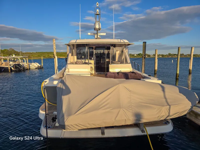 Slide: The Image of 2022 Riviera 505 SUV yacht docked at marina under clear blue sky. - 2