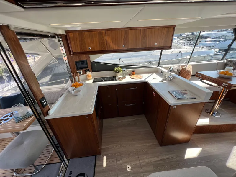 Slide: The Image of Luxurious 2022 Riviera 505 SUV yacht interior with modern kitchen and elegant wood finishes. - 20