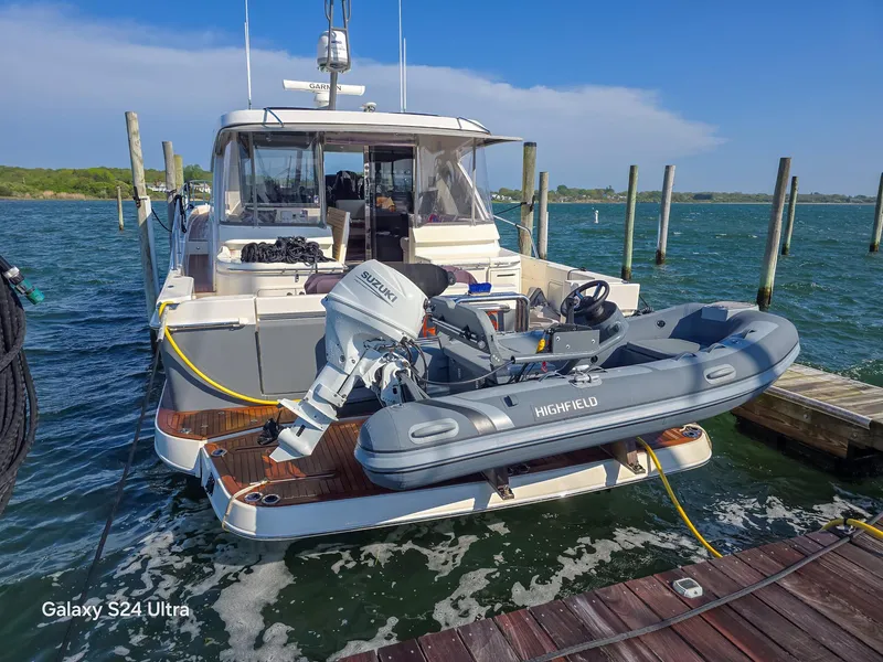 Slide: The Image of 2022 Riviera 505 SUV yacht docked with inflatable boat on lift. - 3