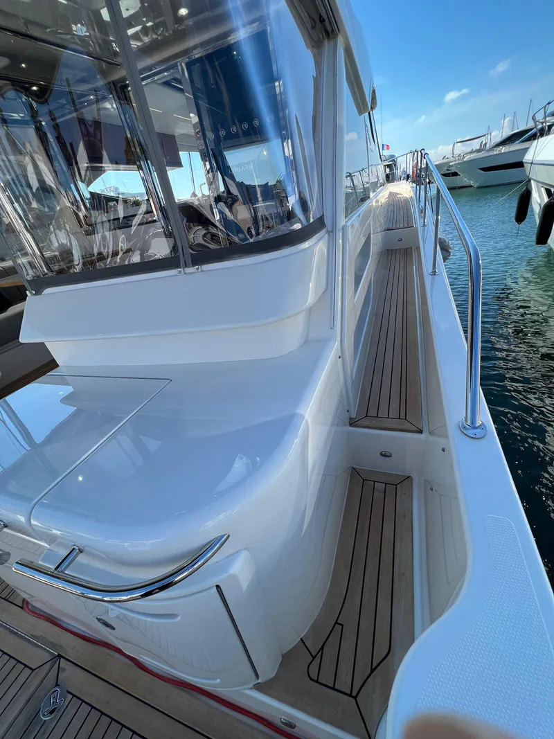 Slide: The Image of 2022 Riviera 505 SUV yacht with sleek design and wooden deck, docked at marina. - 48