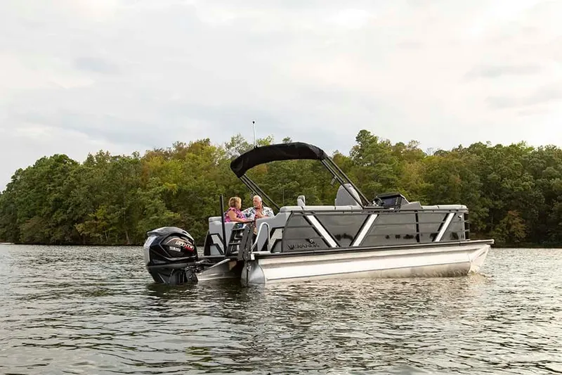 Slide: The Image of 2025 Veranda Vertex 22RC pontoon boat on a serene lake with passengers. - 7