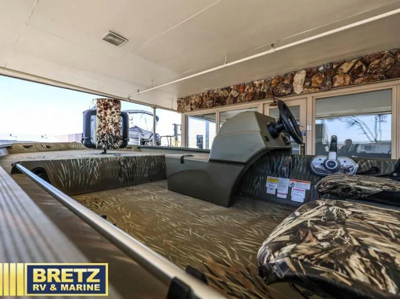 Slide: The Image of 2025 Grizzly 1754 SC boat interior with camouflage seating at Bretz RV & Marine showroom. - 9