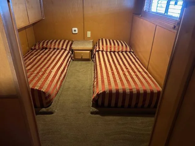 Slide: The Image of Twin beds in a 2007 Lakeview houseboat cabin with striped bedding and wooden interior. - 10