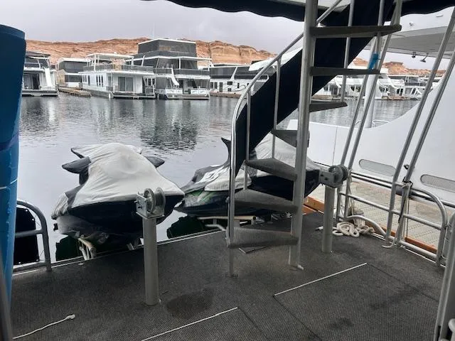 Slide: The Image of Lakeview 2007 houseboat with spiral staircase, jet skis, and marina view. - 13