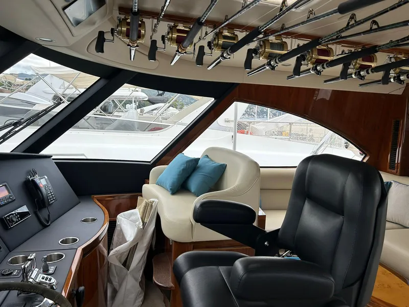 Slide: The Image of Interior of 2018 Viking 62 Enclosed Bridge yacht with fishing rods and seating. - 16