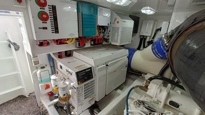 Slide: The Image of Engine room of 2018 Viking 62 Enclosed Bridge with Cummins Onan generator and control panels. - 33