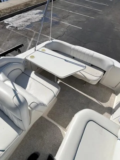 Slide: The Image of 1996 Sea Ray 270 Sundancer boat interior with white seating and table. - 10