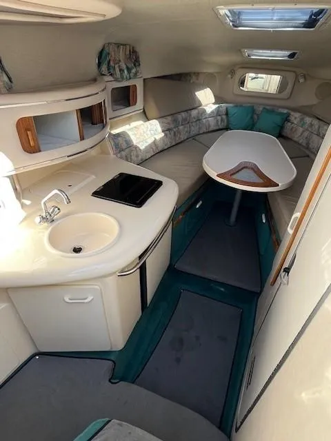 Slide: The Image of 1996 Sea Ray 270 Sundancer cabin interior with kitchenette and seating area. - 13