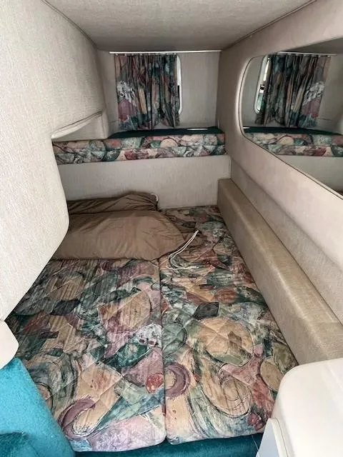 Slide: The Image of Interior cabin of a 1996 Sea Ray 270 Sundancer with patterned bedding and curtains. - 17