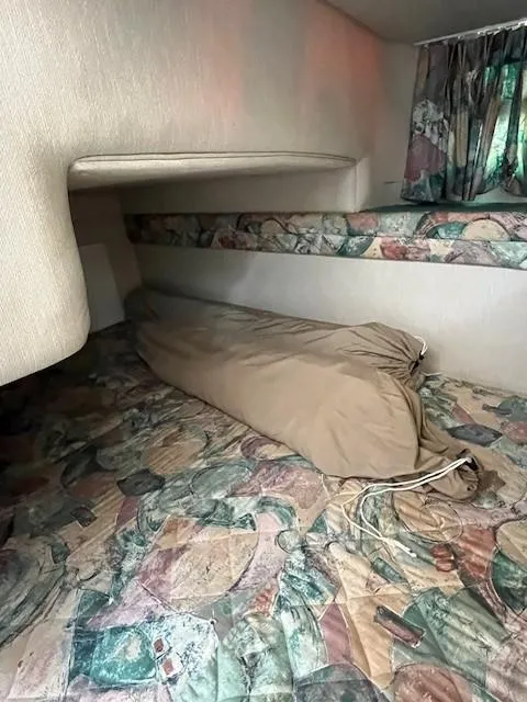 Slide: The Image of Interior cabin of 1996 Sea Ray 270 Sundancer with patterned bedding and storage bag. - 18