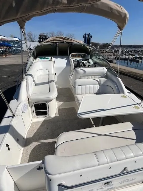 Slide: The Image of 1996 Sea Ray 270 Sundancer boat with spacious seating and canopy, docked at marina. - 7