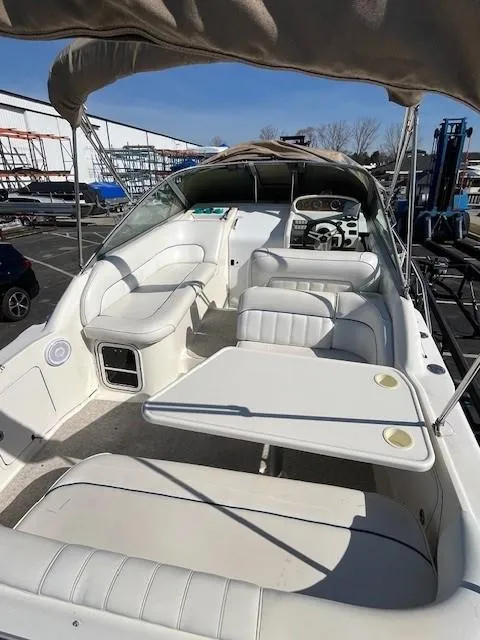 Slide: The Image of 1996 Sea Ray 270 Sundancer boat interior with seating and helm, docked outdoors. - 8
