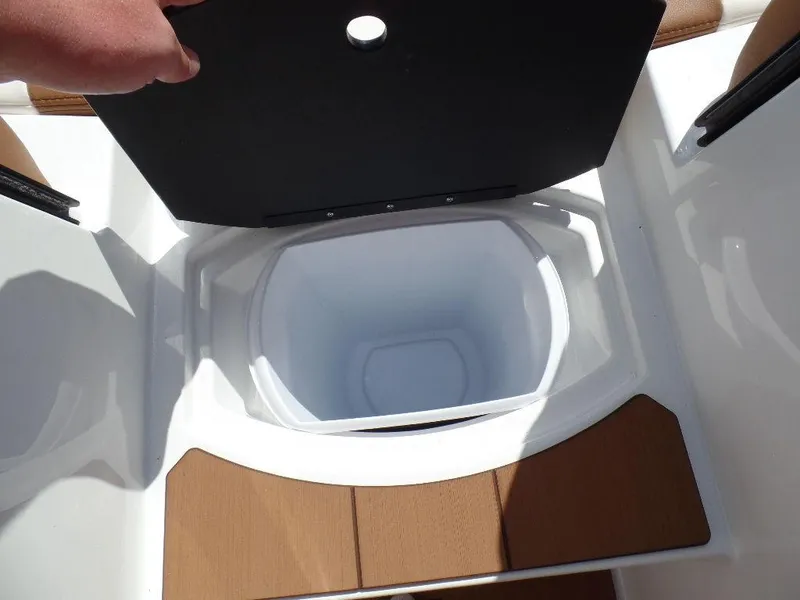 Slide: The Image of 2024 Axis T250 boat storage compartment with open lid, featuring sleek design and wood accents. - 19