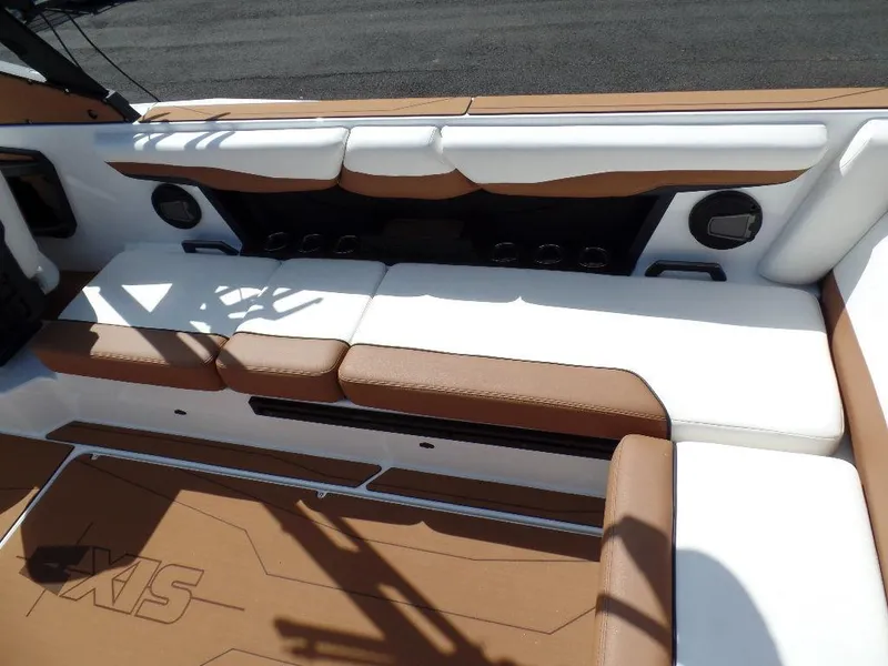 Slide: The Image of 2024 Axis T250 boat interior with brown and white seating, featuring built-in speakers. - 6