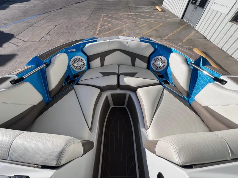 Slide: The Image of 2022 Centurion Fi25 boat interior with gray and blue seating, cup holders, and speakers. - 11