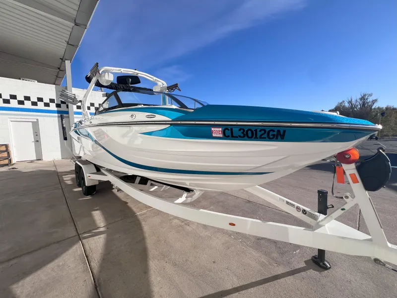 Slide: The Image of 2022 Centurion Fi25 boat on trailer, parked outdoors under clear blue sky. - 3