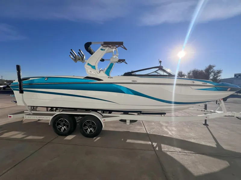 Slide: The Image of 2022 Centurion Fi25 boat on trailer under clear blue sky. - 4