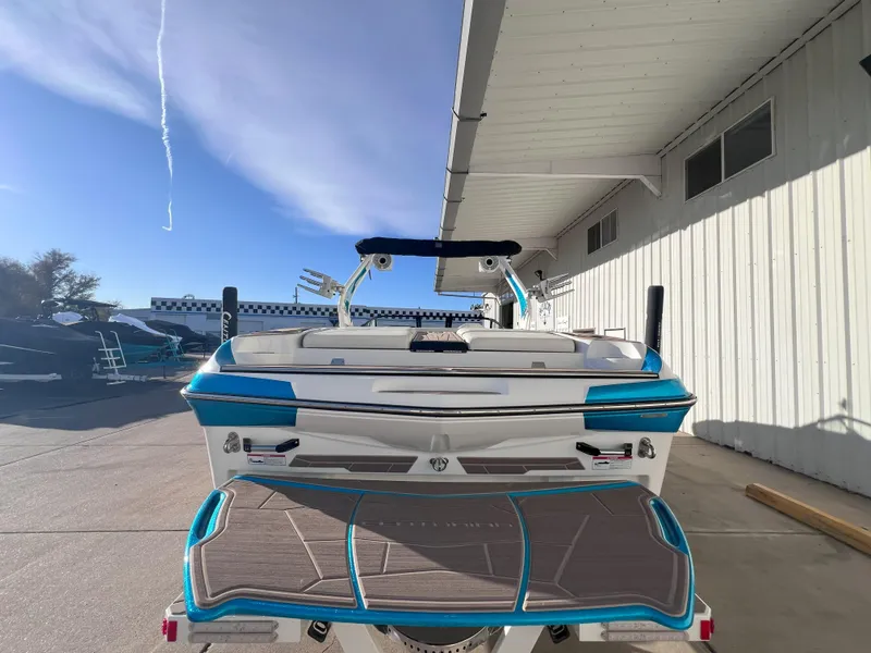 Slide: The Image of 2022 Centurion Fi25 boat, rear view, parked outdoors near a building. - 7