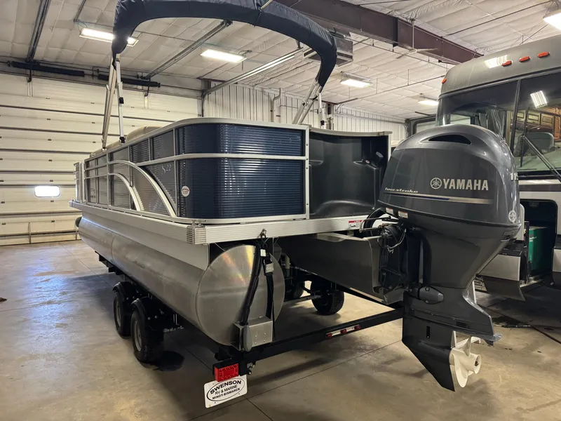 Slide: The Image of 2020 Bennington SX 22 SSRX pontoon boat with Yamaha motor in a garage setting. - 2