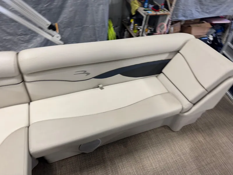 Slide: The Image of 2020 Bennington SX 22 SSRX boat seating, beige upholstery with dark accents, in a storage area. - 6