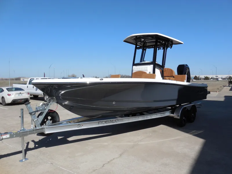 Slide: The Image of 2025 Robalo 246 Cayman boat on trailer, parked outdoors under clear blue sky. - 4