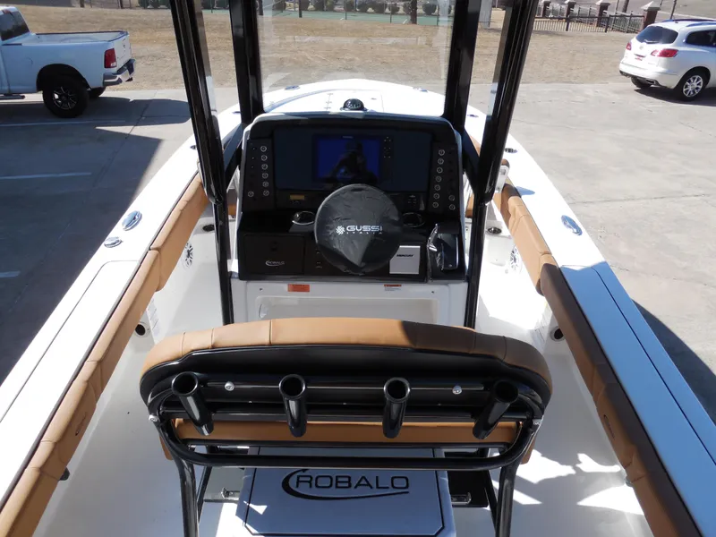 Slide: The Image of 2025 Robalo 246 Cayman boat interior with console and seating in a parking lot. - 6