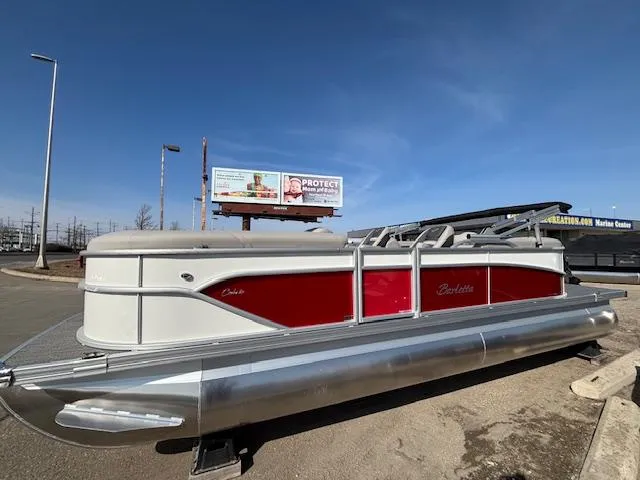 Slide: The Image of 2025 Barletta Cabrio 22QC pontoon boat with red and white design, parked outdoors. - 1