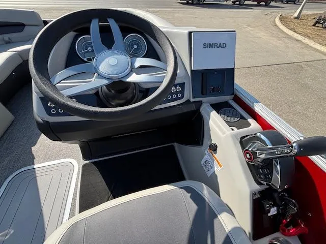 Slide: The Image of 2025 Barletta Cabrio 22QC boat dashboard with steering wheel and Simrad display. - 11