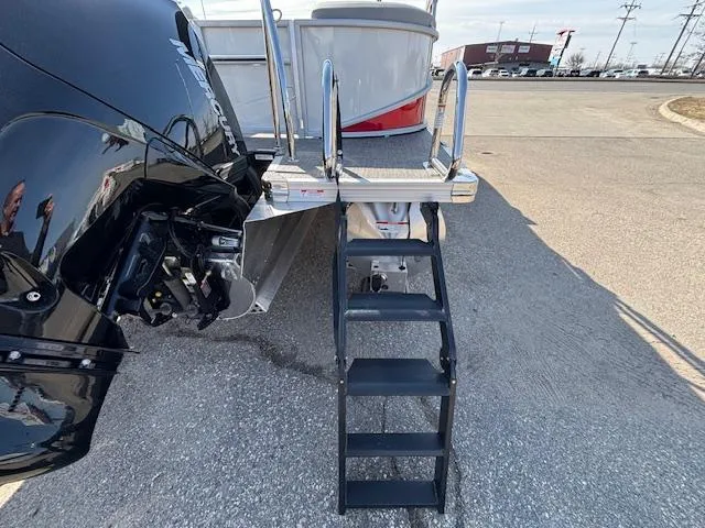 Slide: The Image of 2025 Barletta Cabrio 22QC boat with rear ladder and motor, parked on pavement. - 24