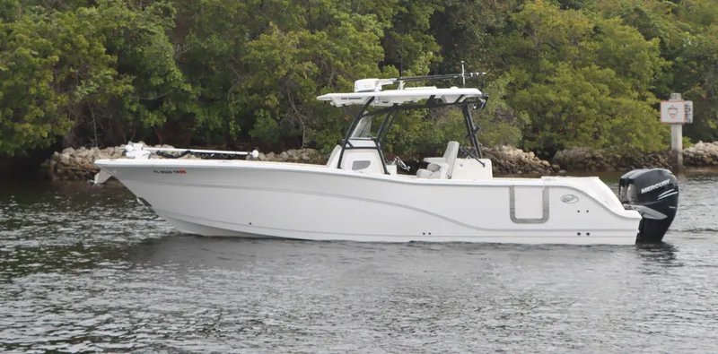 Slide: The Image of 2023 Sea Fox 328 Commander boat on water, surrounded by lush greenery. - 0