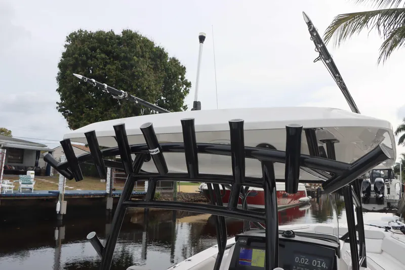 Slide: The Image of 2023 Sea Fox 328 Commander boat with fishing rod holders, docked near a canal. - 25