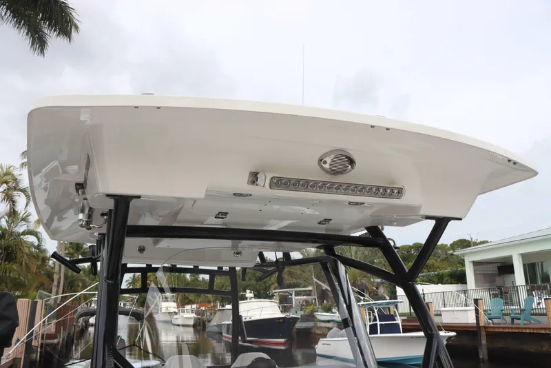 Slide: The Image of 2023 Sea Fox 328 Commander boat with T-top and lighting, docked near waterfront homes. - 26