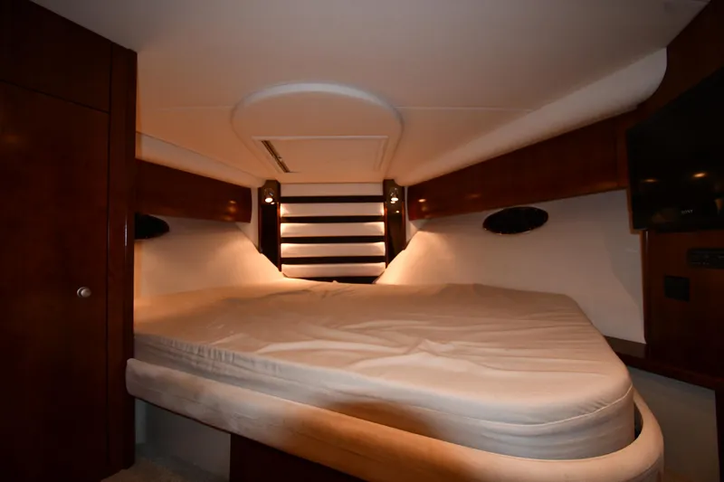 Slide: The Image of 2012 Cruisers Yachts 390 Sports Coupe interior cabin with bed and wooden accents. - 28