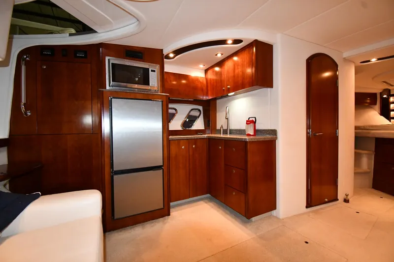 Slide: The Image of Luxurious 2012 Cruisers Yachts 390 Sports Coupe interior kitchen with wood cabinetry and modern appliances. - 35
