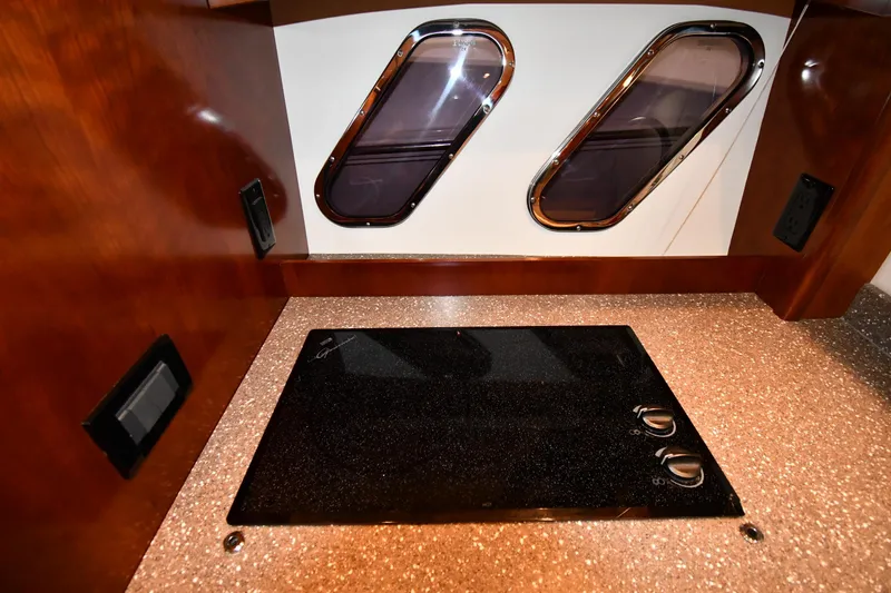 Slide: The Image of 2012 Cruisers Yachts 390 Sports Coupe interior with sleek cooktop and porthole windows. - 42