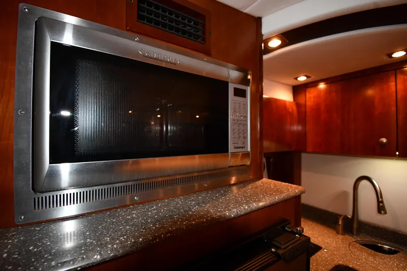 Slide: The Image of Microwave in 2012 Cruisers Yachts 390 Sports Coupe kitchen, featuring wood cabinetry and modern design. - 43