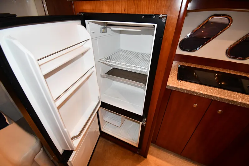 Slide: The Image of 2012 Cruisers Yachts 390 Sports Coupe interior with open refrigerator and kitchenette. - 44