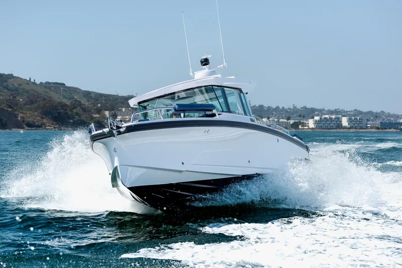Slide: The Image of 2025 Axopar 29XC Cross Cabin Aft Cabin boat on sandy shore. - 3