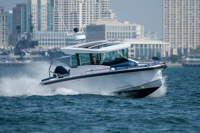 Slide: The Image of 2025 Axopar 29XC Cross Cabin Aft Cabin boat on sandy beach, clear sky, calm water. - 5