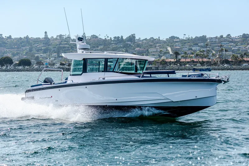 Slide: The Image of 2025 Axopar 29XC Cross Cabin Aft Cabin boat beached on sandy shore. - 6