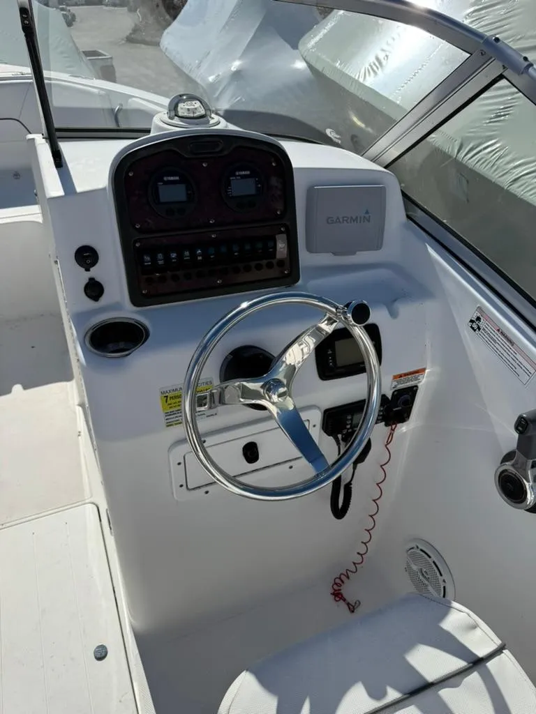 Slide: The Image of 2016 Sea Hunt Escape 211 boat dashboard with steering wheel and controls. - 2