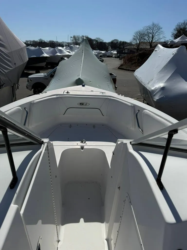 Slide: The Image of 2016 Sea Hunt Escape 211 boat, docked, with covered vessels in the background. - 3