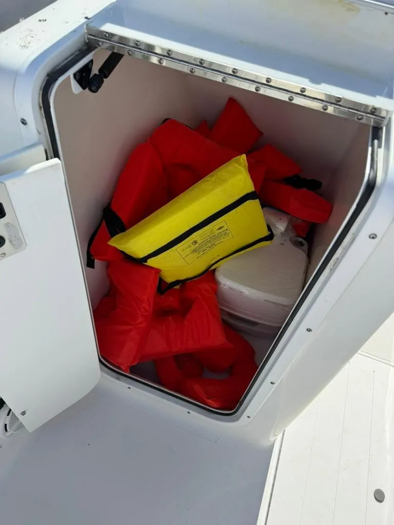 Slide: The Image of Storage compartment with life jackets on a 2016 Sea Hunt Escape 211 boat. - 6