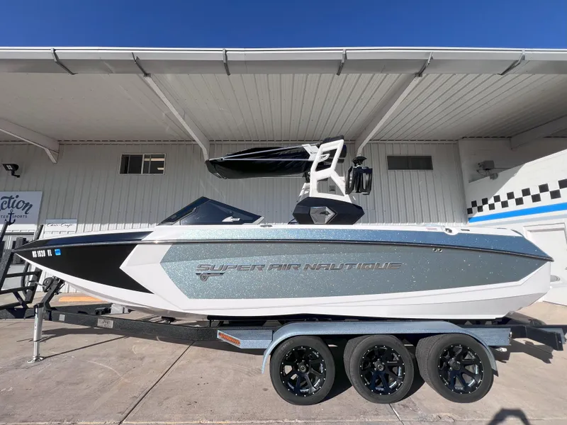 Slide: The Image of 2019 Nautique Super Air Nautique G25 boat on a trailer, parked outdoors. - 1